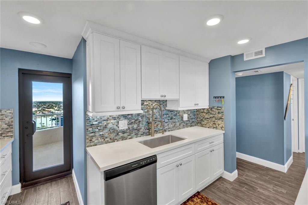 Kitchen with white cabinetry, dishwasher, dark wood-style flooring, and recessed lighting