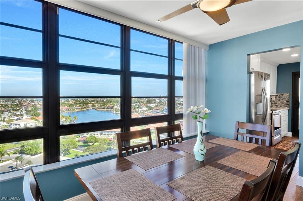 Dining area with ceiling fan and a water view