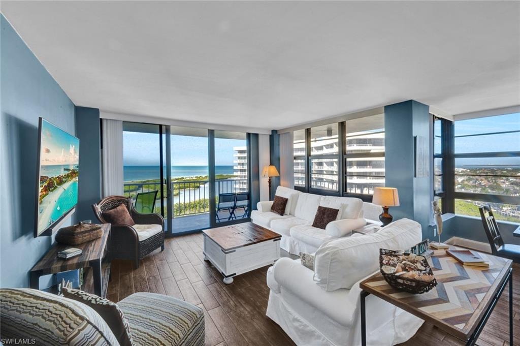Living area with wood finished floors, plenty of natural light, and expansive windows