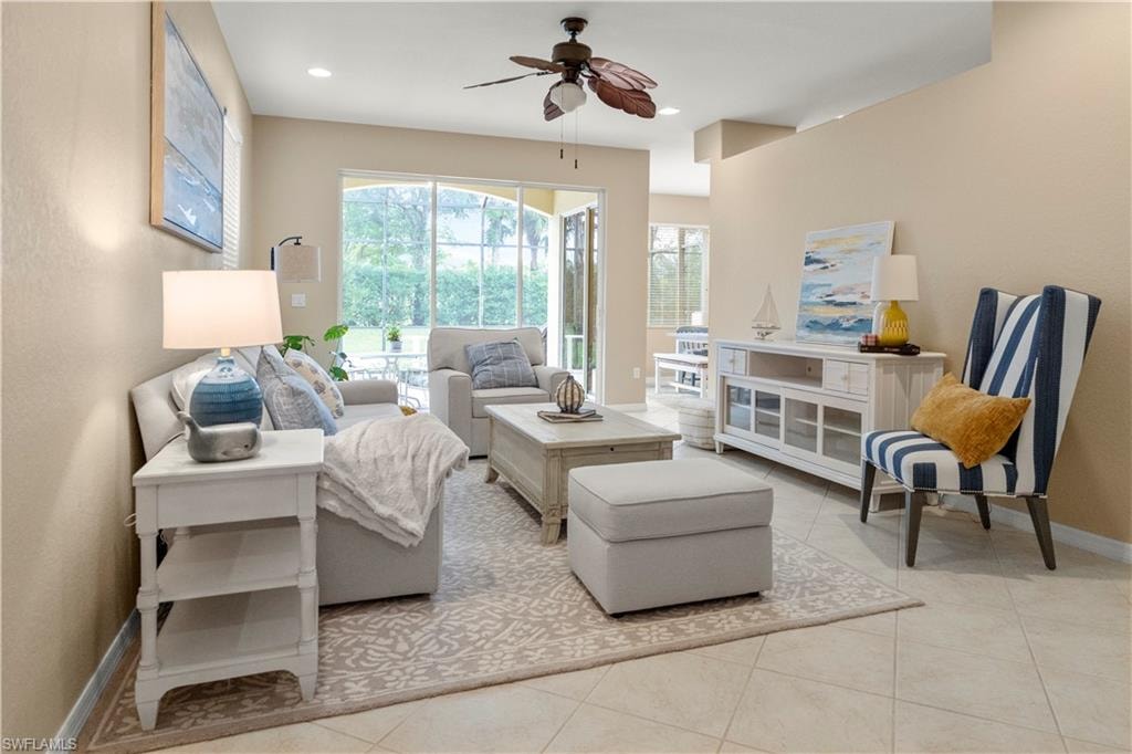 Living area with a ceiling fan, light tile patterned flooring, and recessed lighting