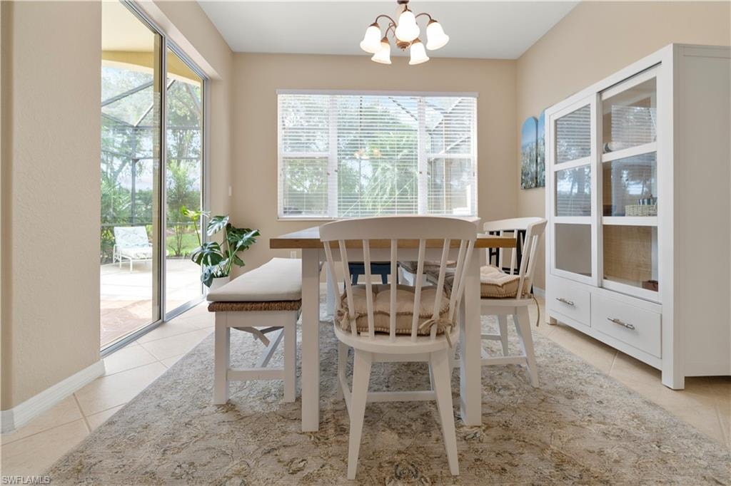 Dining area with a chandelier, healthy amount of natural light, and light tile patterned flooring