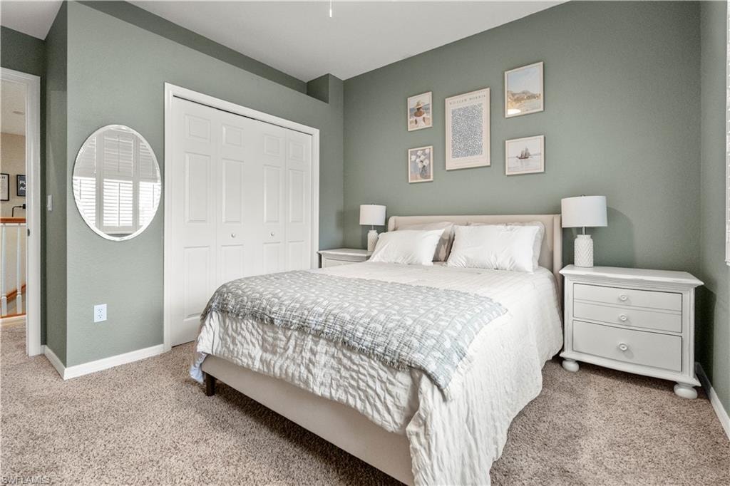 Carpeted bedroom with a closet and a ceiling fan