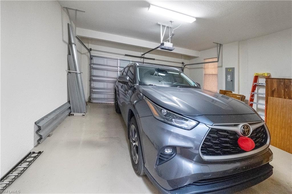 Garage featuring electric panel and a garage door opener