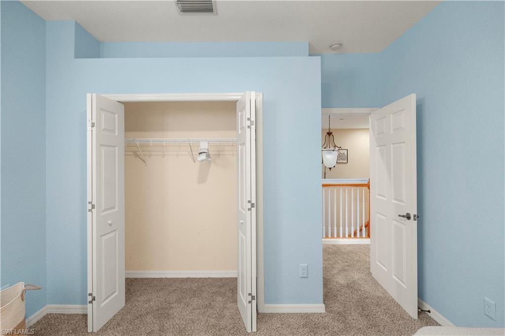 Unfurnished bedroom featuring light carpet and a closet