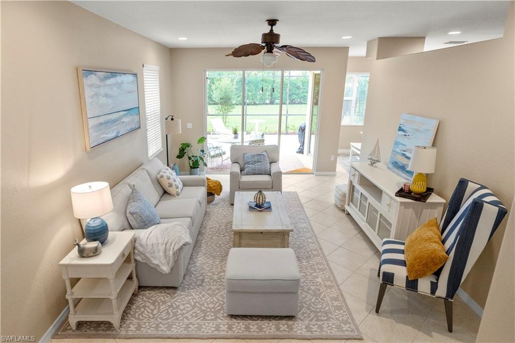 Living area featuring light tile patterned floors and a ceiling fan