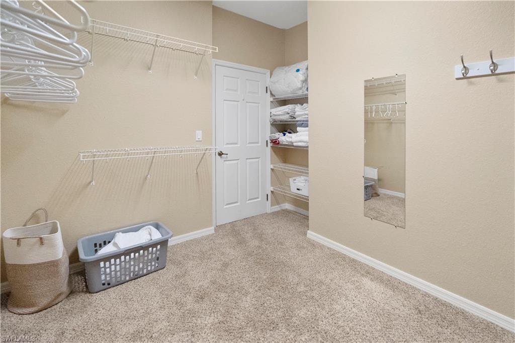 Walk in closet with light carpet