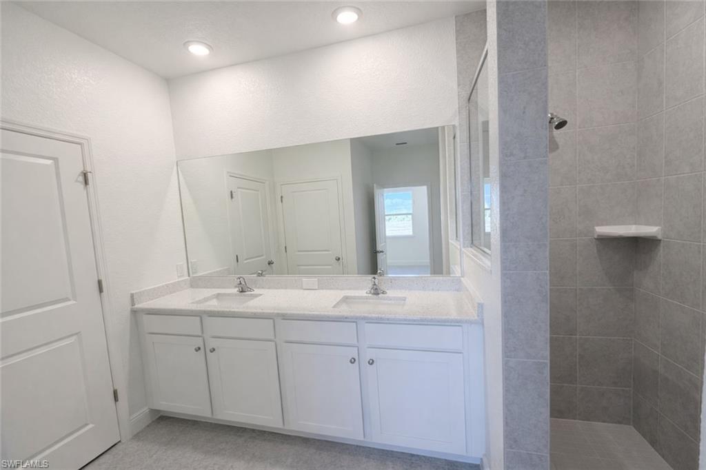 Full bathroom with walk in shower and double vanity