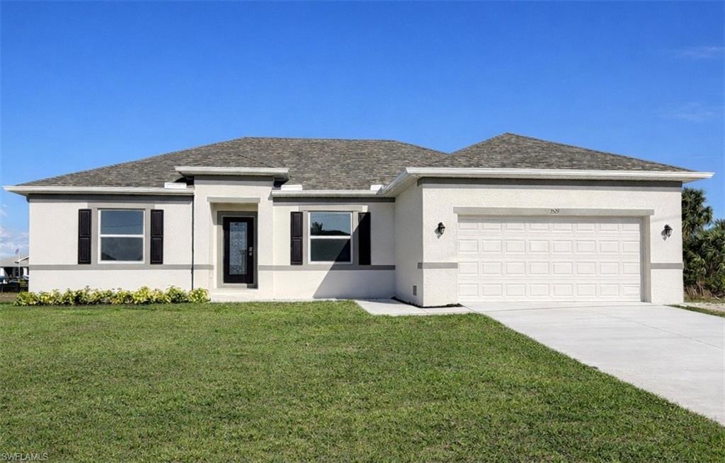 View of front of house with stucco siding, a front yard, an attached garage, and driveway