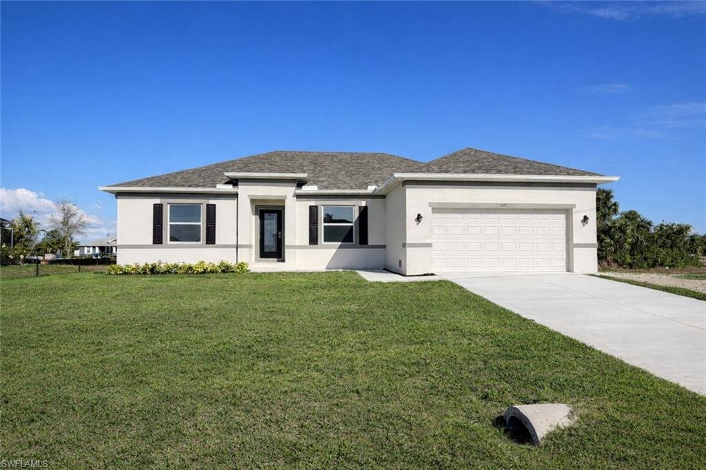 Prairie-style house featuring stucco siding, a front lawn, a garage, concrete driveway, and roof with shingles