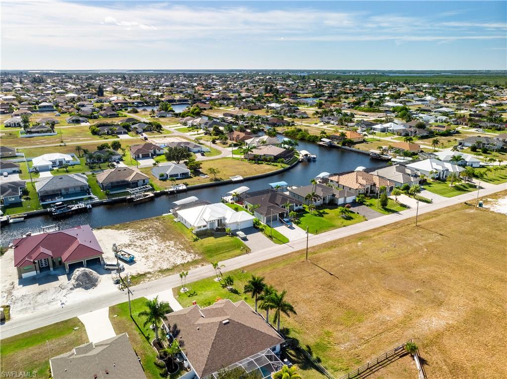 Aerial perspective of suburban area featuring a nearby body of water