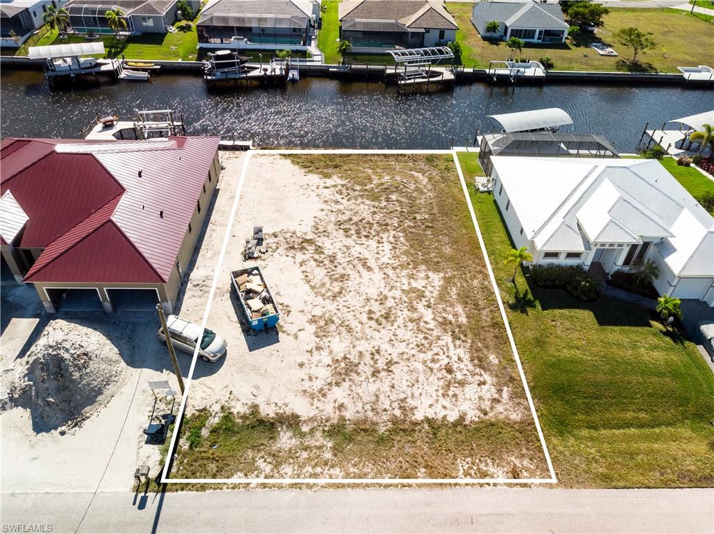 Aerial view of residential area featuring a nearby body of water and property boundaries highlighted