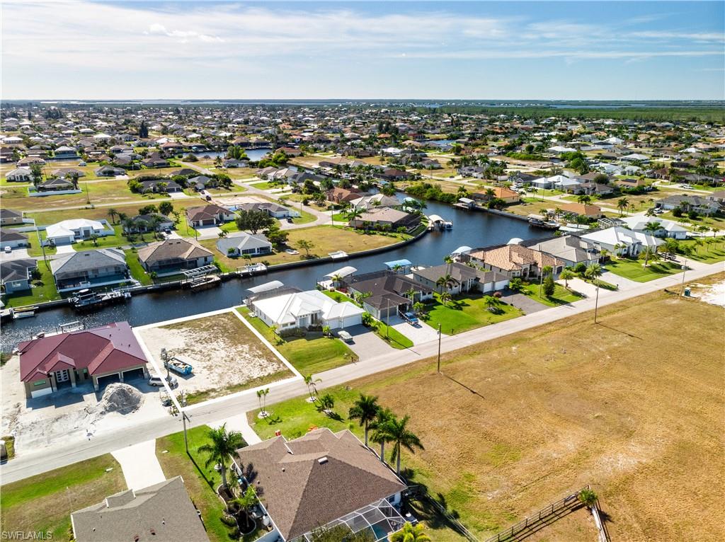 Aerial perspective of suburban area featuring a nearby body of water