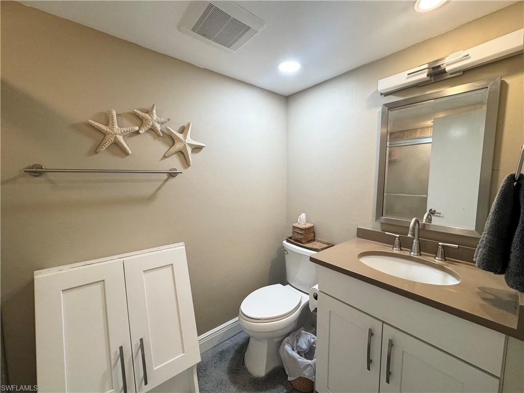 Full bath featuring vanity, a shower with door, and recessed lighting