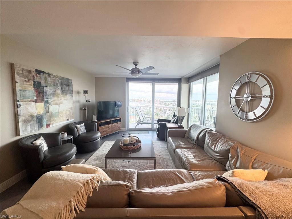 Living area featuring floor to ceiling windows and ceiling fan