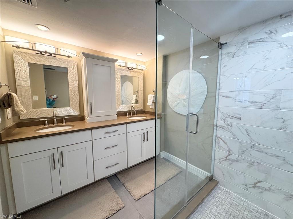 Bathroom featuring a stall shower and double vanity