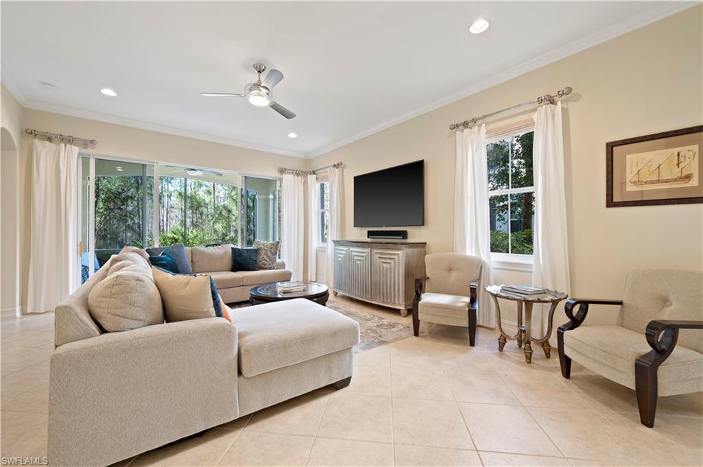 Living room with light tile patterned flooring, ornamental molding, ceiling fan, and recessed lighting