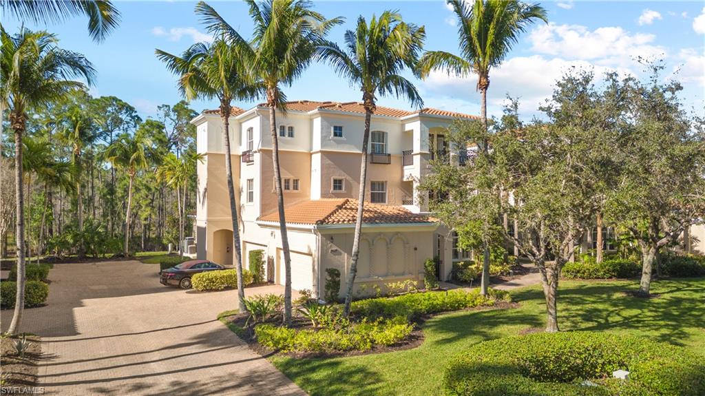 View of property featuring decorative driveway and an attached garage