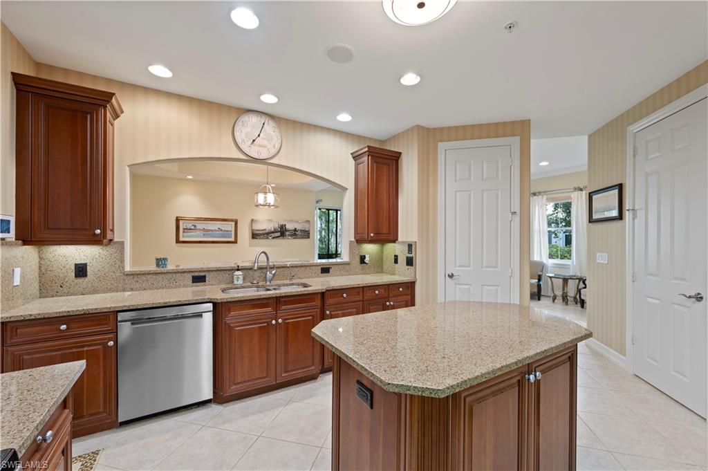 Kitchen with stainless steel dishwasher, light stone counters, light tile patterned flooring, and recessed lighting