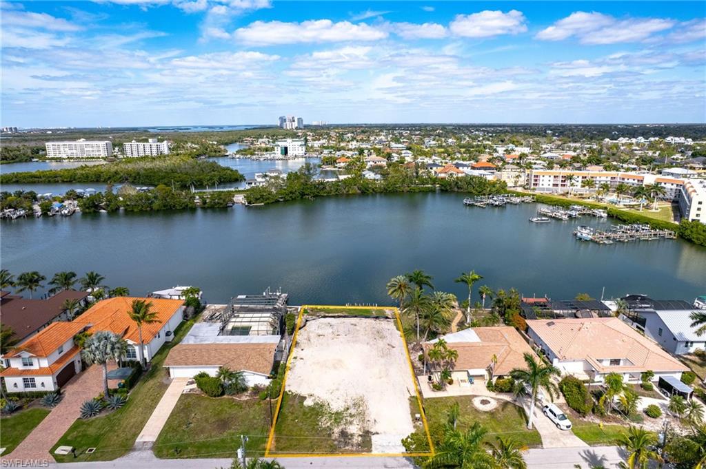 Aerial overview of property's location featuring a nearby body of water, property boundaries highlighted, and a marina