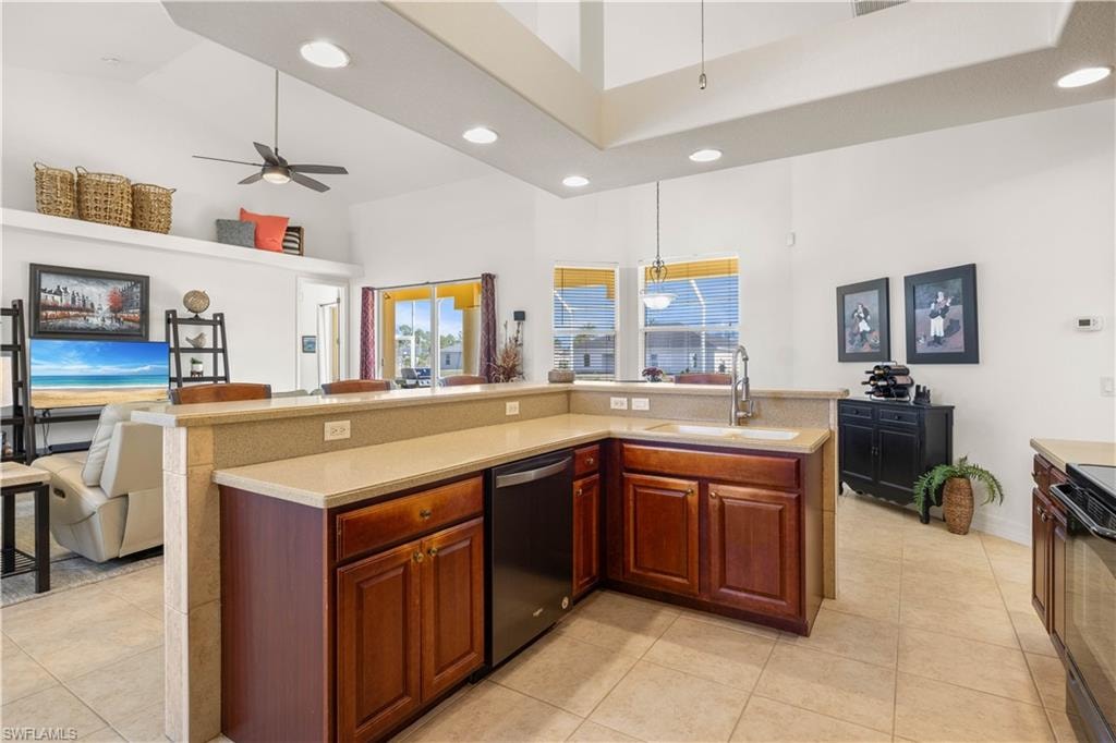 Kitchen with recessed lighting, a kitchen island with sink, dishwasher, high vaulted ceiling, and open floor plan