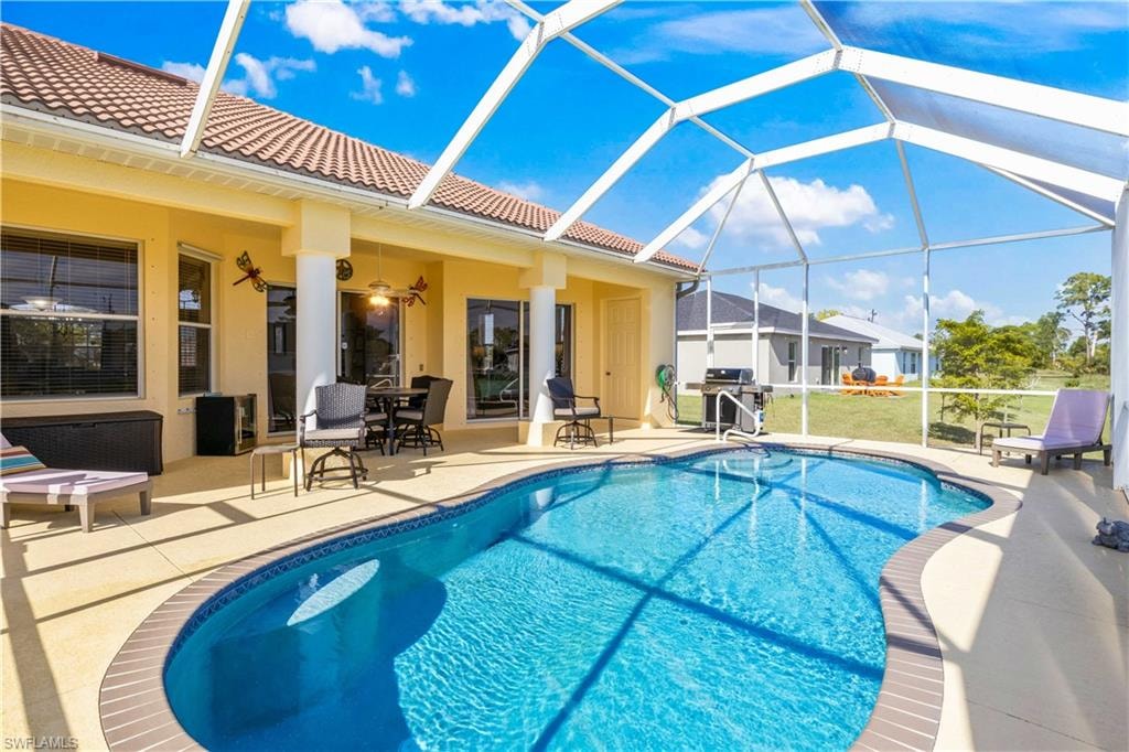 Swimming pool featuring a patio, a lanai, a sunroom, and outdoor dining area
