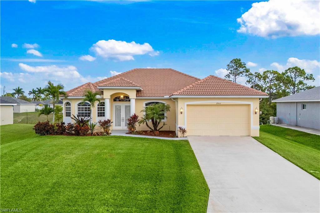 Mediterranean / spanish house featuring concrete driveway, stucco siding, and a front lawn