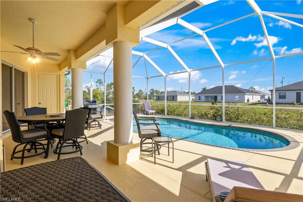 Swimming pool with a sunroom, a patio area, glass enclosure, and outdoor dining space