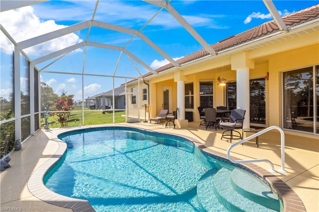 Swimming pool featuring a patio, glass enclosure, a sunroom, and a lawn