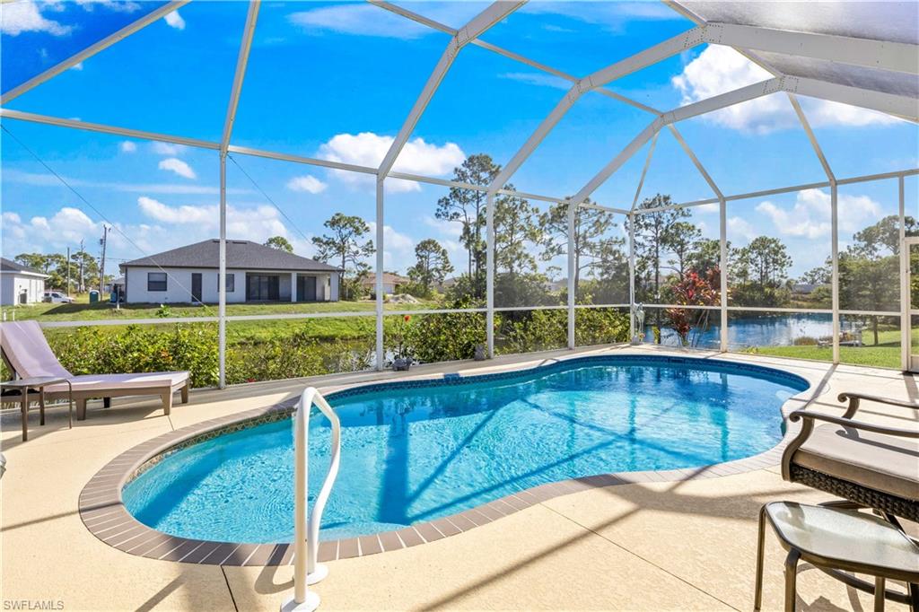 Swimming pool with a sunroom, a lanai, and a patio