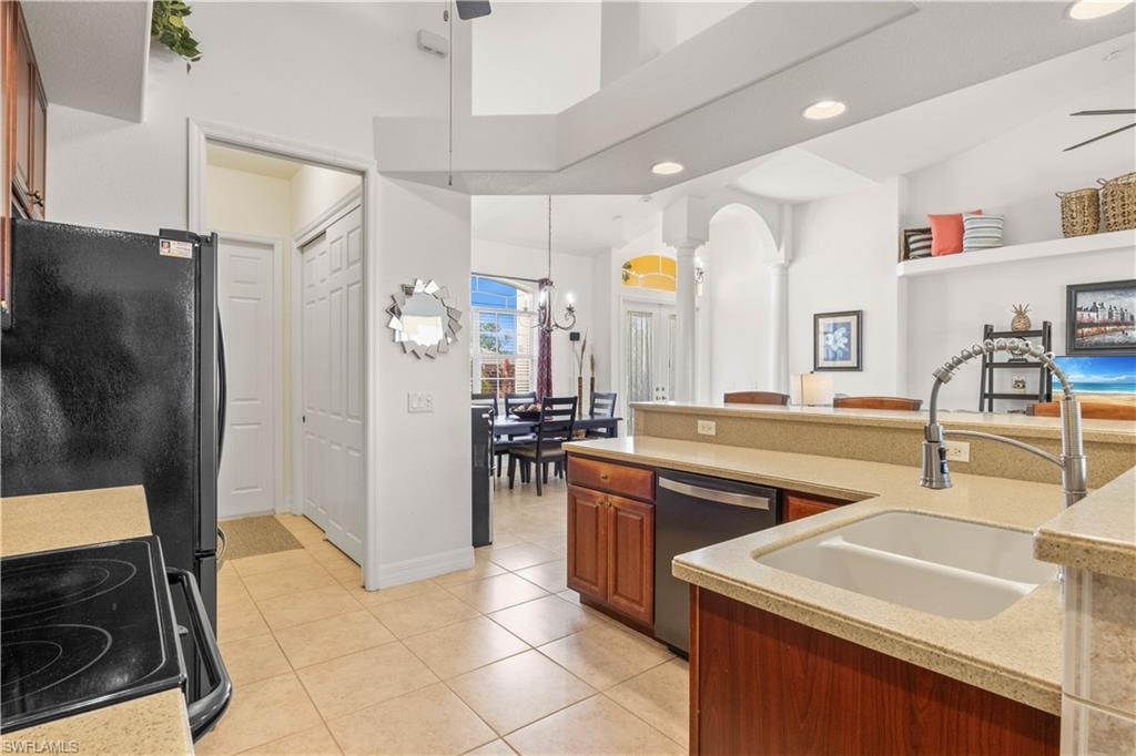 Kitchen featuring range with electric cooktop, stainless steel dishwasher, light tile patterned flooring, brown cabinets, and recessed lighting