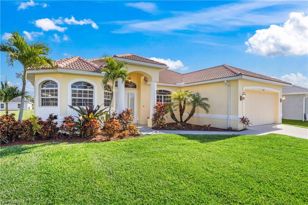Mediterranean / spanish-style home featuring stucco siding, an attached garage, a front yard, driveway, and a tile roof