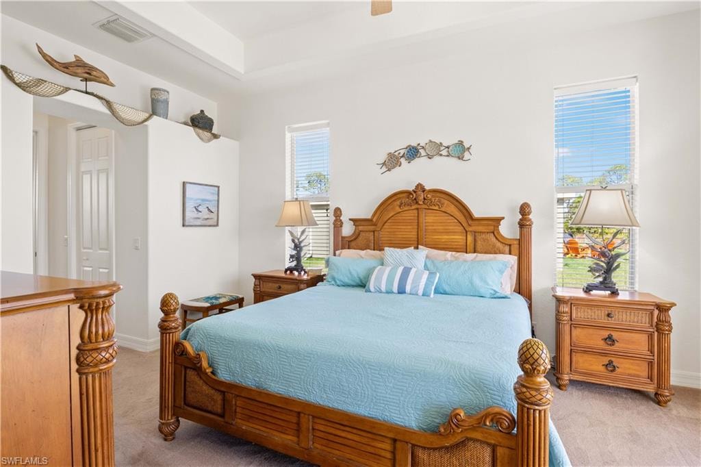 Bedroom with light carpet, a ceiling fan, and a closet
