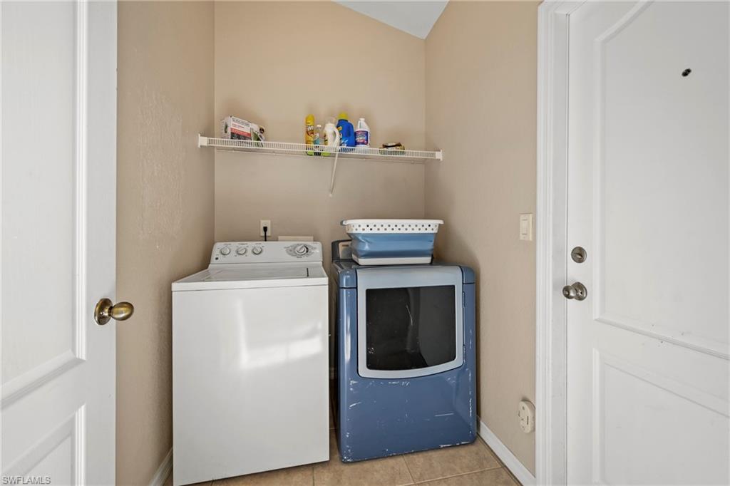 Washroom featuring tile patterned flooring and washer and dryer