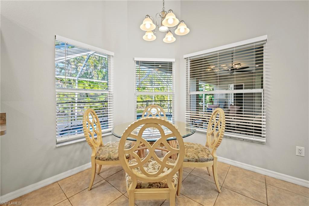 Kitchen featuring dishwasher, white cabinets, decorative light fixtures, arched walkways, and high vaulted ceiling