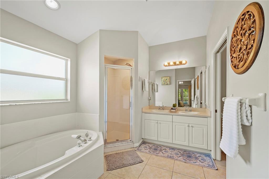 Bedroom featuring high vaulted ceiling, light carpet, and a ceiling fan