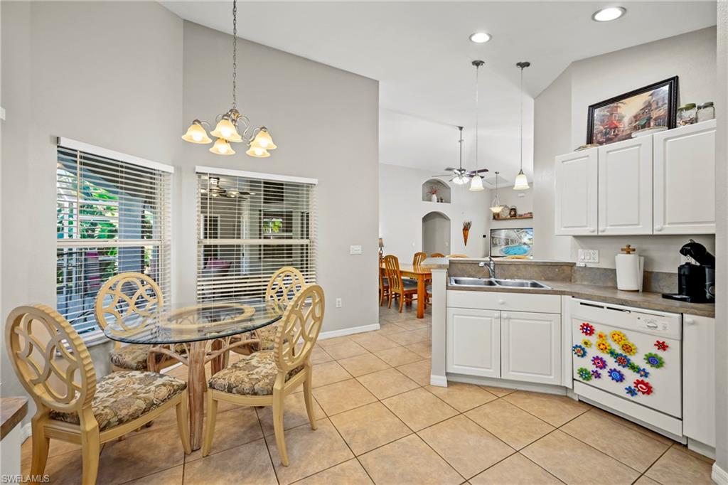 Kitchen with white appliances, white cabinetry, light countertops, recessed lighting, and light tile patterned floors