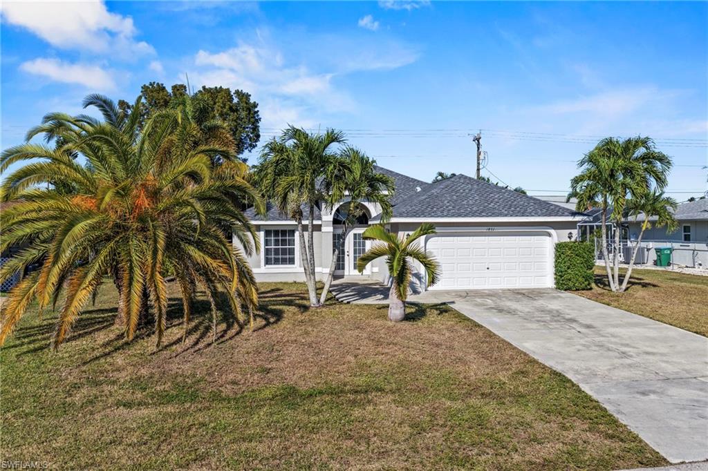 View of front of property with stucco siding, french doors, a garage, and a front yard