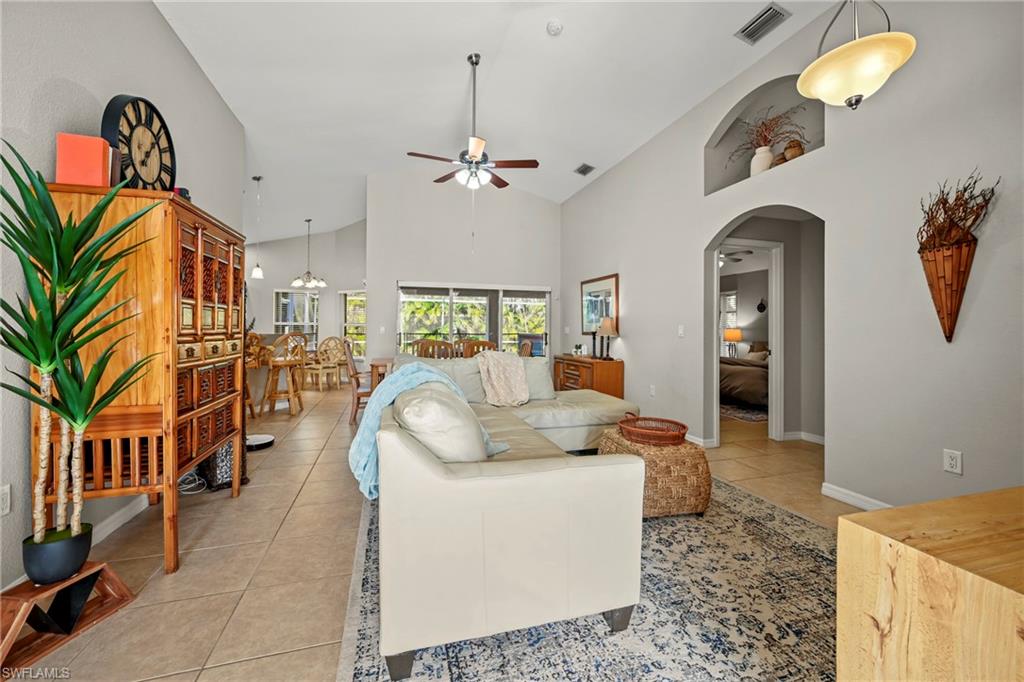 Entrance foyer with a chandelier, french doors, lofted ceiling, and light tile patterned floors
