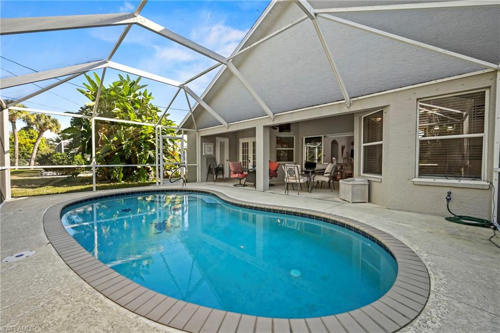 Swimming pool with a patio, a sunroom, and a lanai