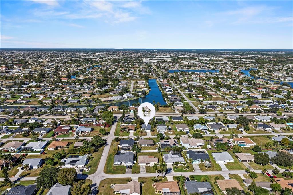 Aerial view of property and surrounding area featuring nearby suburban area and a large body of water