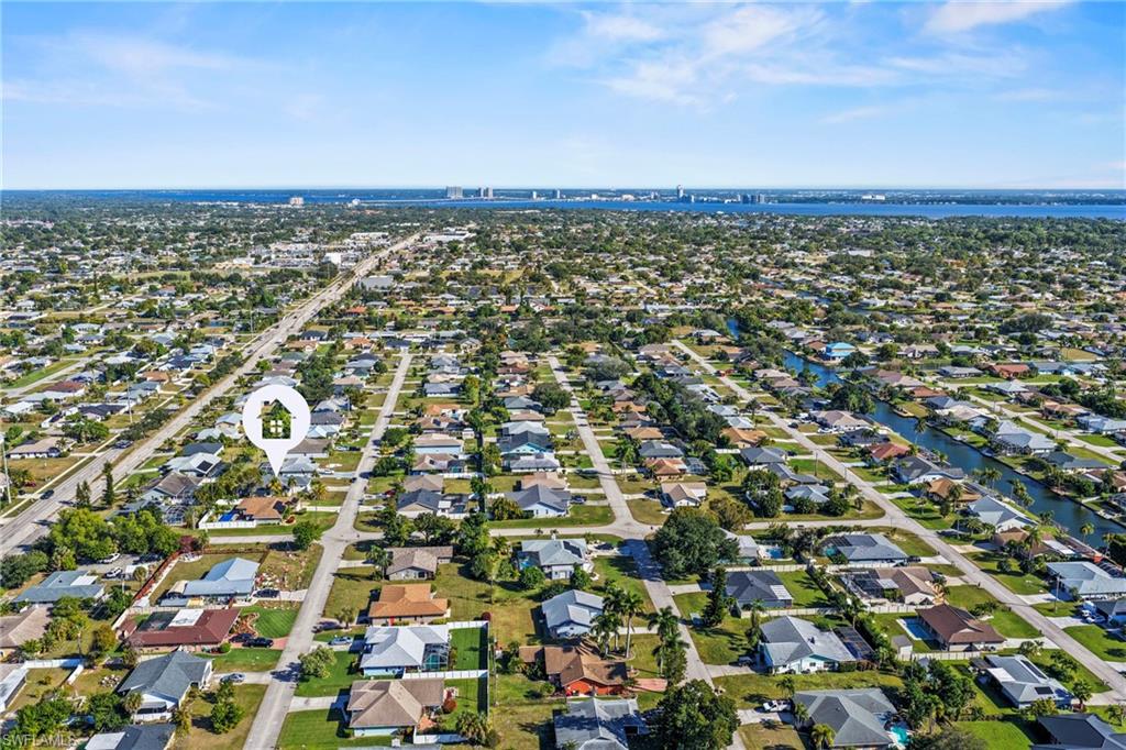 Aerial view of property and surrounding area featuring nearby suburban area