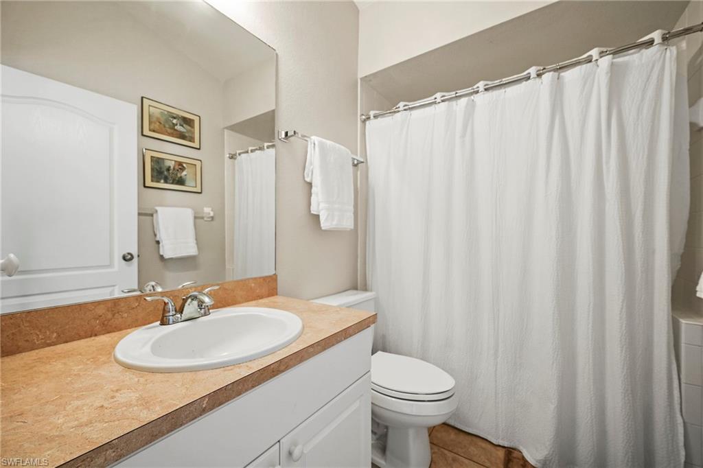 Bathroom with vanity, a shower with curtain, and tile patterned flooring