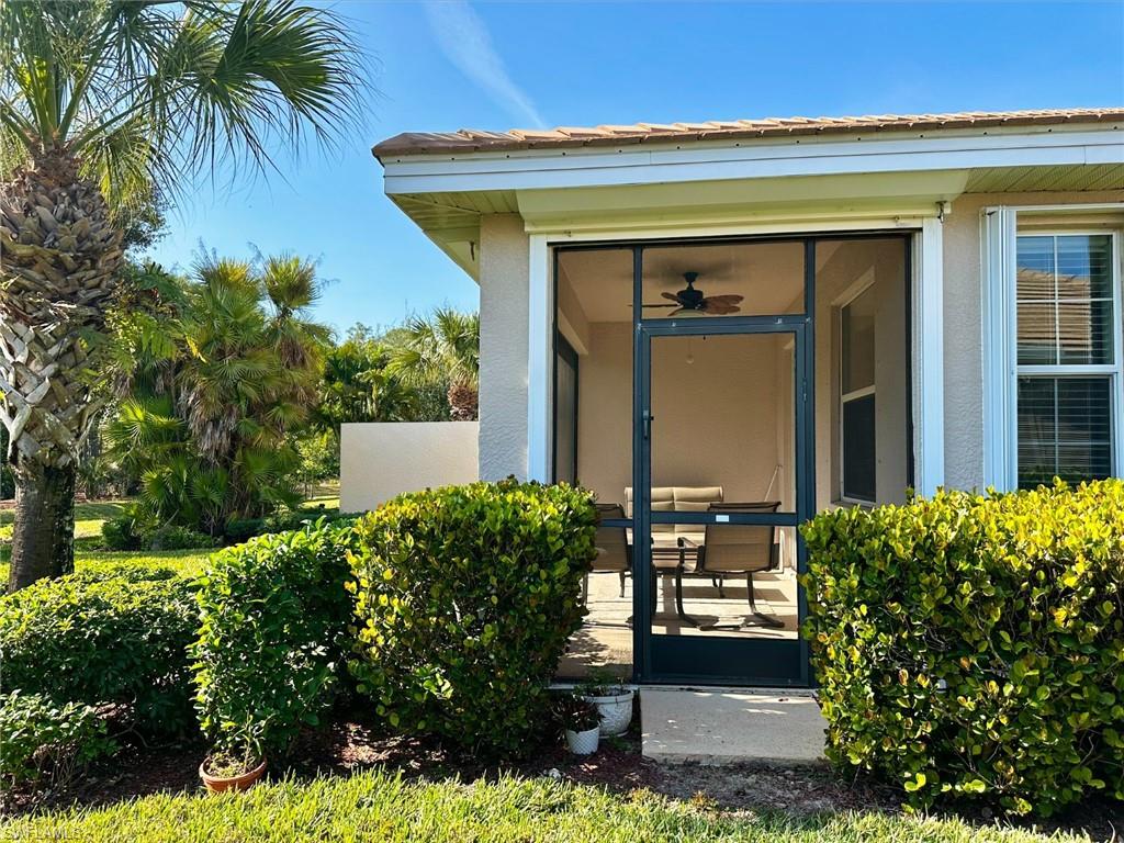Entrance to property featuring a sunroom, stucco siding, and ceiling fan