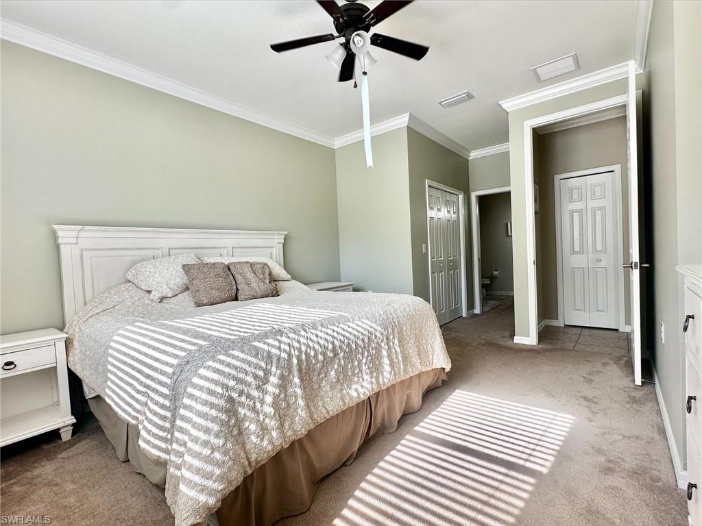 Bedroom with carpet flooring, ornamental molding, and a ceiling fan