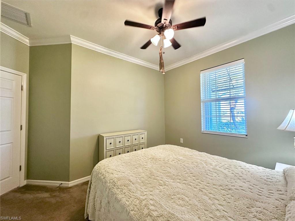 Bedroom featuring crown molding, carpet floors, and ceiling fan