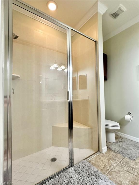 Bathroom with crown molding and a shower stall