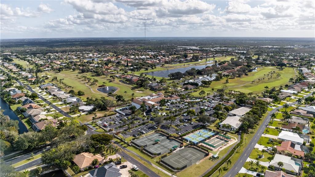 Aerial overview of property's location featuring a golf course and nearby suburban area