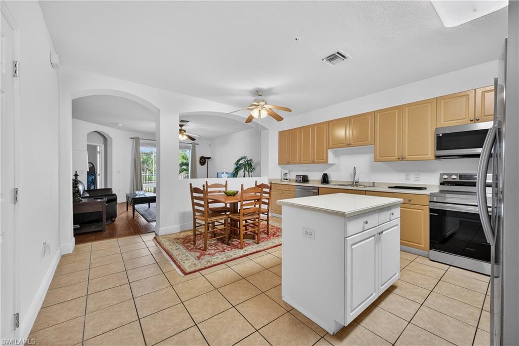 Large Kitchen, Center Island,  featuring light countertops, New and newer appliances with stainless steel finishes, arched walkways, light tile patterned floors, and ceiling fan