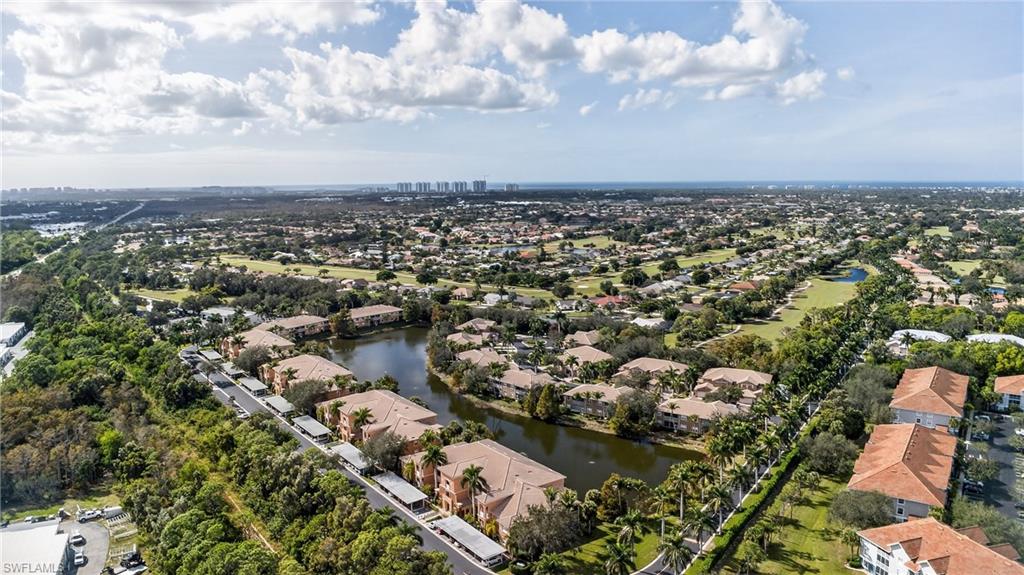 Aerial view of property and surrounding area featuring a large body of water and nearby suburban area