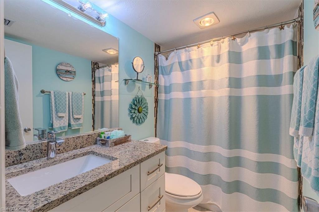 Bathroom with a shower with shower curtain and vanity
